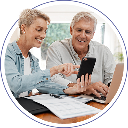 man and woman smiling at a mobile phone
