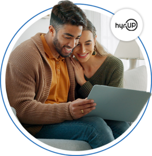 Image of a young man and women leaning against each other while looking at a laptop