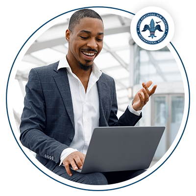 Image of a young black man wearing a suit on his laptop at the airport