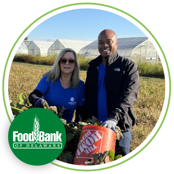 Image of a man and woman in a field holding a food barrel