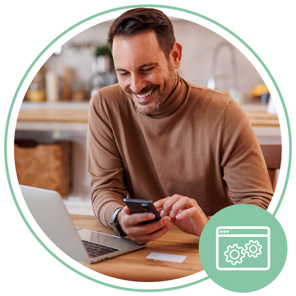 Man smiling and using his mobile phone at a desk