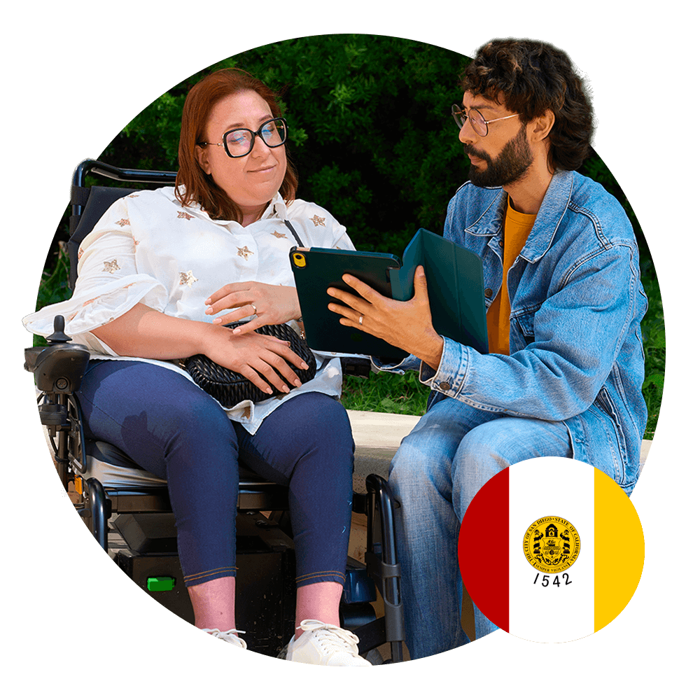 man showing woman in wheelchair something on a tablet