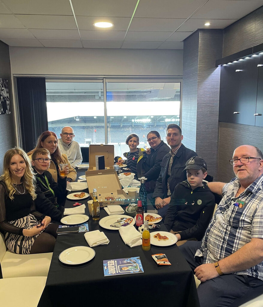 Michael, Laura and the the competition winners sat around the table eating pizza in the box