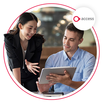 man and woman at work smiling and looking at a tablet