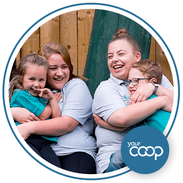 2 adults and 2 children hugging and smiling