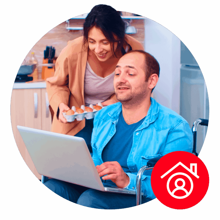Disabled man and partner using a laptop in a kitchen